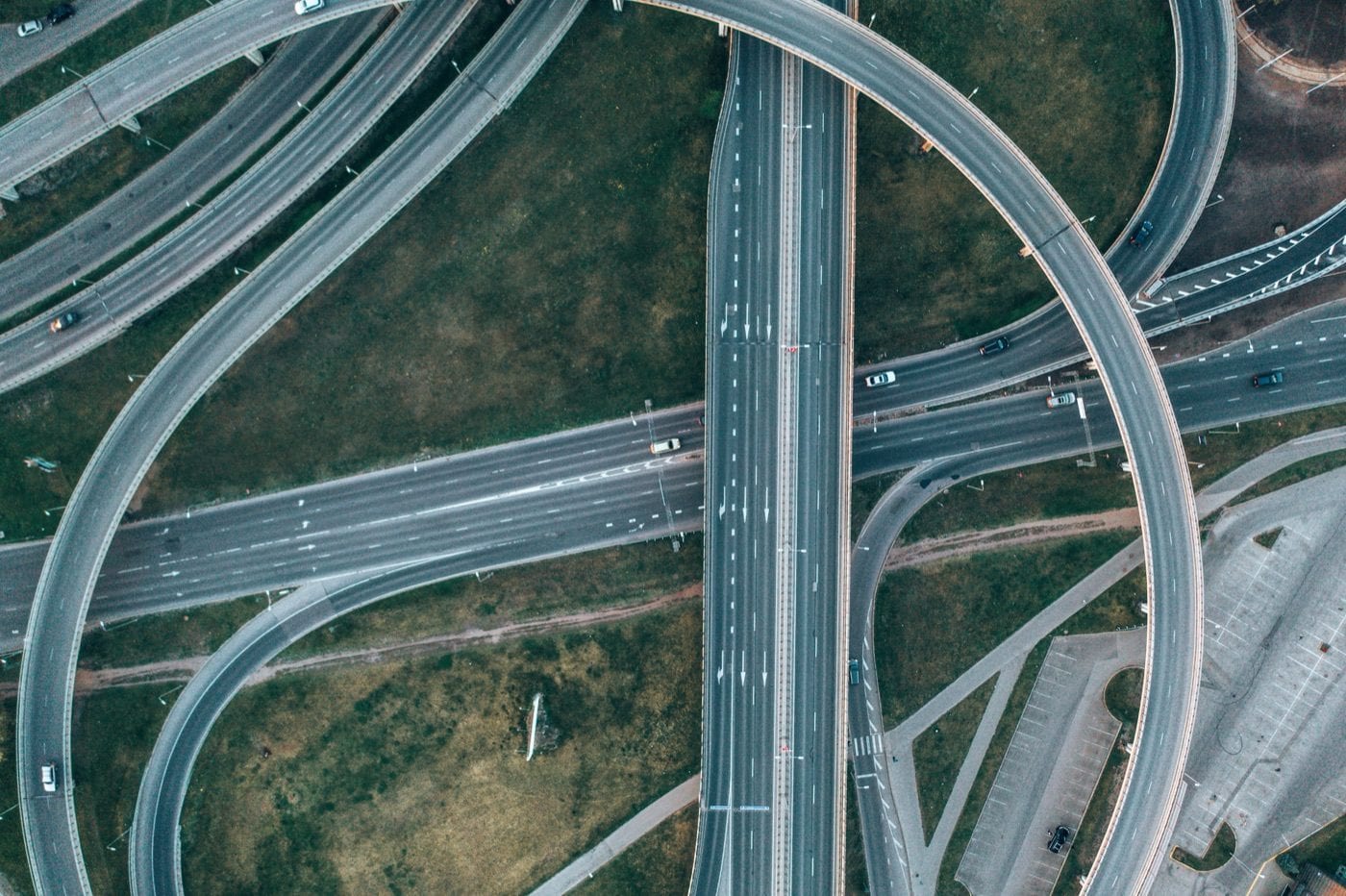 Luftaufnahme eines mehrspurigen Autobahnkreuzes mit sich kreuzenden Fahrspuren